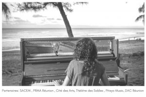 Lise Van Dooren de dos, en train de joker du piano au bord d'une plage réunionnaise