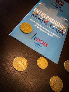 Brochure Iedom posée sur une table avec quelques pièces