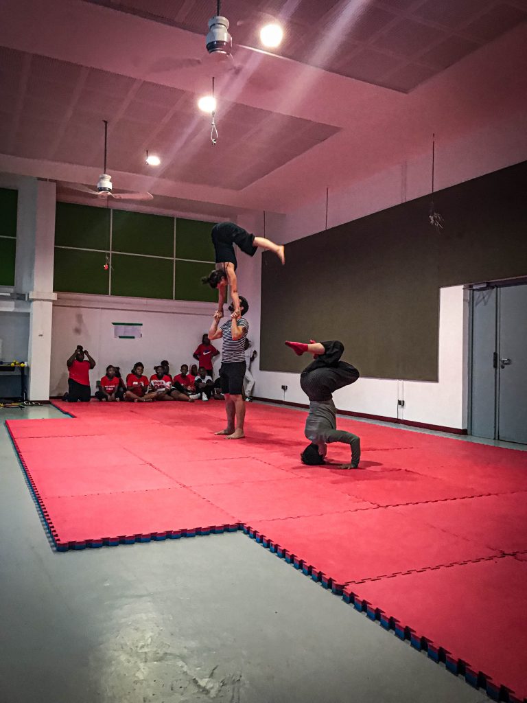 3 personnes donnant spectacle artistique devant des enfants émerveillés 