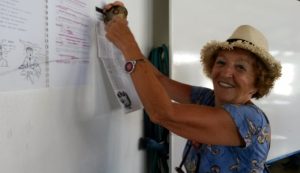 Madame Serre accroche ses photos et ses panneaux, comme une prof prépare son cours