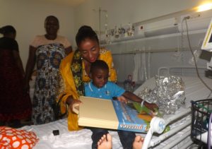 Moinécha Soumaila, élue en binôme avec l'actuel président du conseil départemental, remet son cadeau à un petit garçon pressé d'ouvrir le paquet