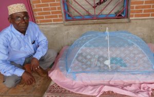 Assani Mfoungoulié pose aux côtés d'un bébé de quelques semaines
