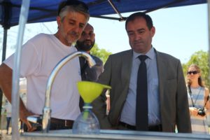 Le préfet devant un simulateur de robinet qui fuit.
